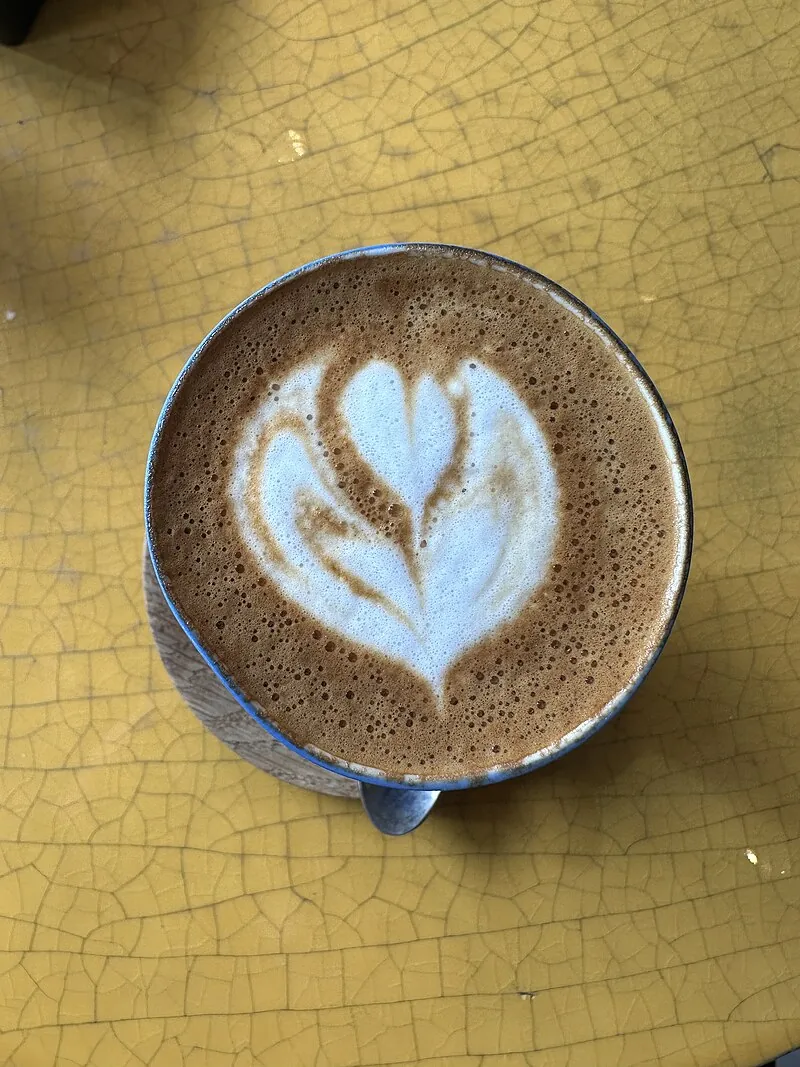 A cortado served in a small glass, showing the layered espresso and warm milk