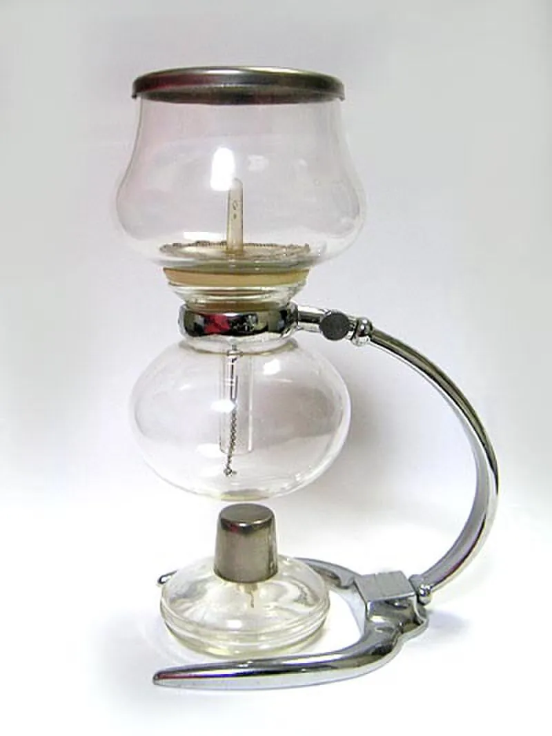 Glass siphon coffee maker with two chambers on a stand, with spirit burner below