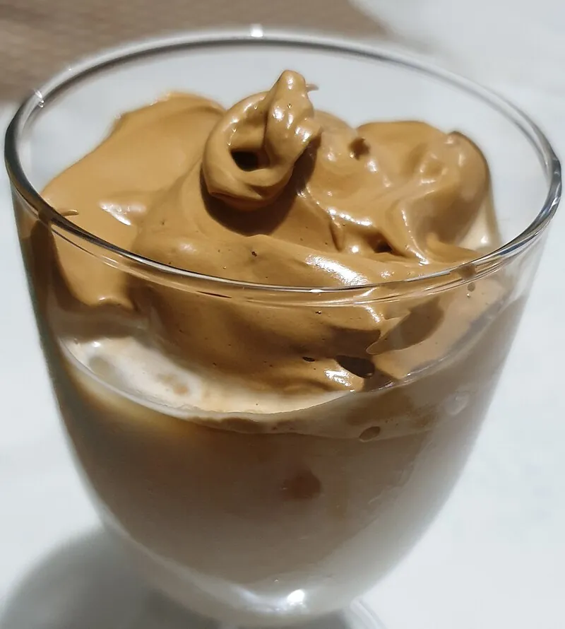 Dalgona whipped coffee in a glass with ice