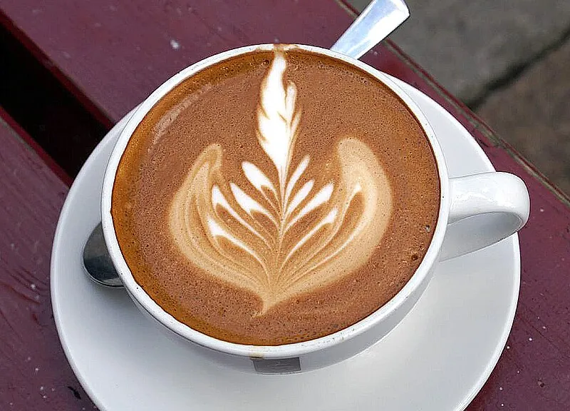 A flat white with latte art — the result of correctly texturised milk poured through espresso