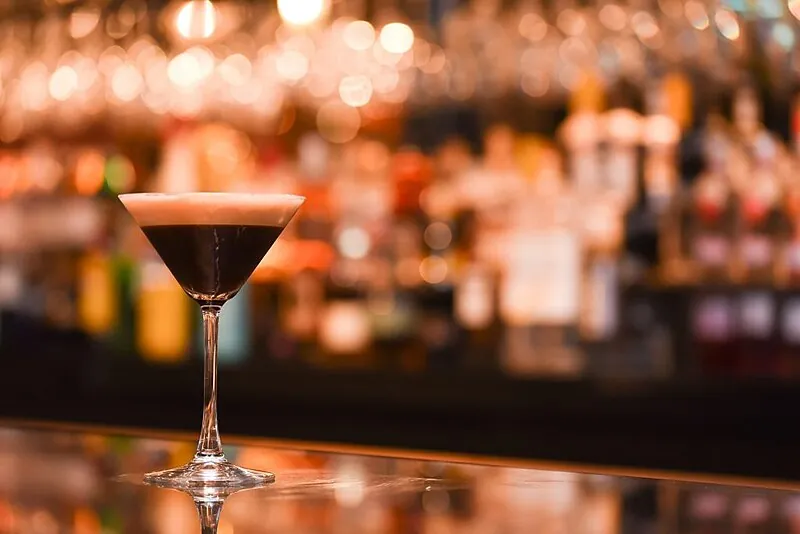 An espresso martini — vodka, coffee liqueur, fresh espresso and sugar syrup shaken and strained into a cocktail glass, topped with three coffee beans