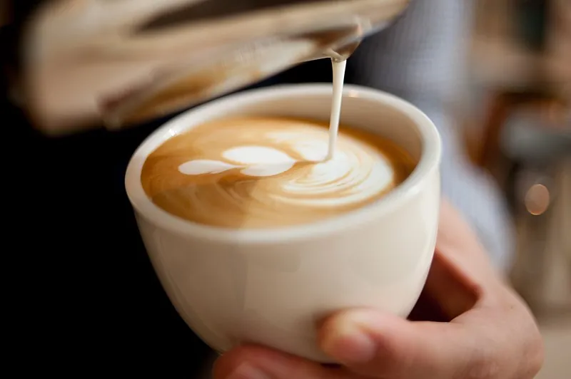 A caffe latte with latte art in a glass cup